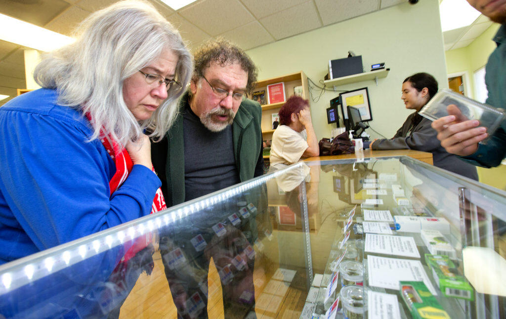 Stormy Knight, left, and Marc Harris of Santa Rosa shop for cannabis products on the first day legal recreational marijuana sales in Sonoma County at SPARc/Peace in Medicine in Sebastopol on Monday morning, January 1, 2018.  (photo by John Burgess/The Press Democrat)