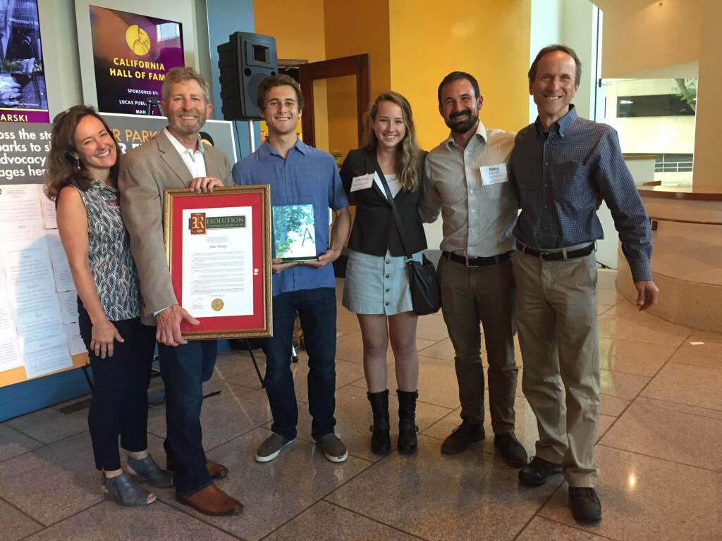 John Roney holds up the citation recognizing his heroism during the October fires at the California State Senate. With him are his wife Mary Jo Dale, his children Jack and Kate, and the Sonoma Ecology Center's Tony Passentino and Richard Dale. (SUBMITTED)