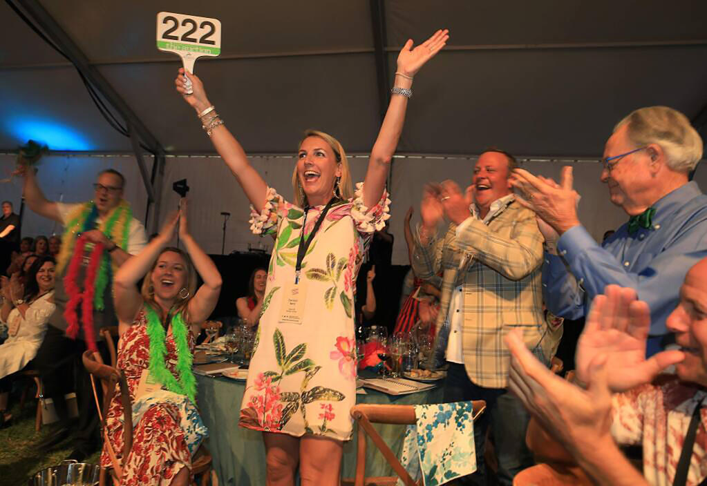 Caroline Betz of St. Louis celebrates her winning bid of $300,000 for a trip to Texas and other items during the Sonoma County Wine Auction in Windsor in 2019. Many traditional Wine Country fundraising events are returning this year after a two-year hiatus. (Kent Porter / The Press Democrat