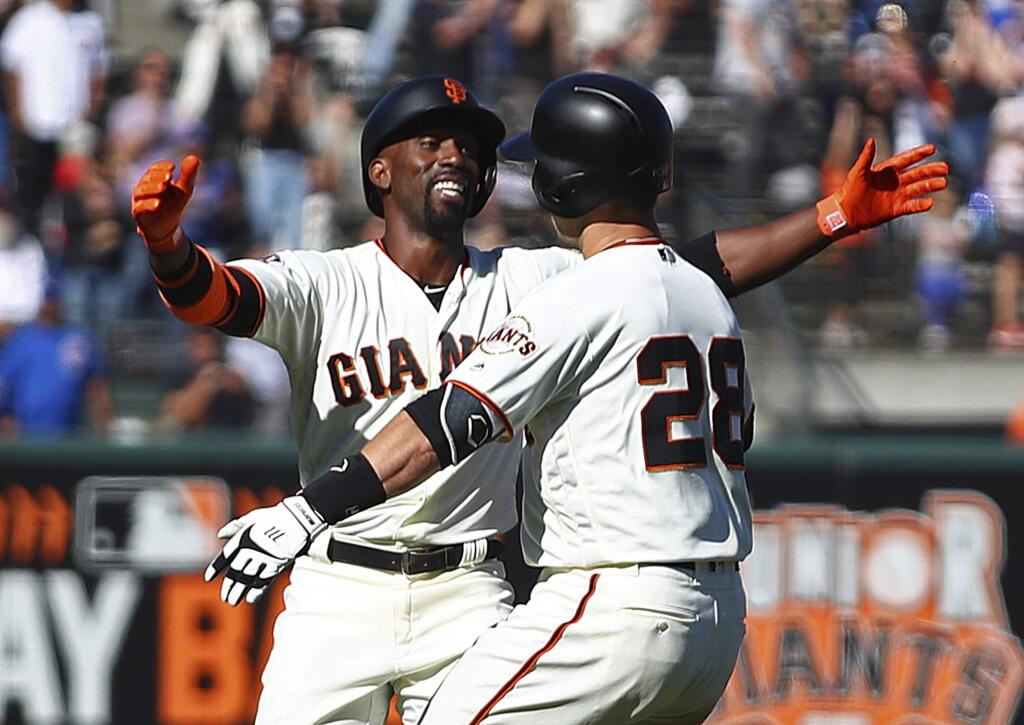 The San Francisco Giants' Buster Posey, right, celebrates with Andrew McCutchen after making the game-winning hit against the Chicago Cubs in the 13th inning Wednesday, July 11, 2018, in San Francisco. (AP Photo/Ben Margot)