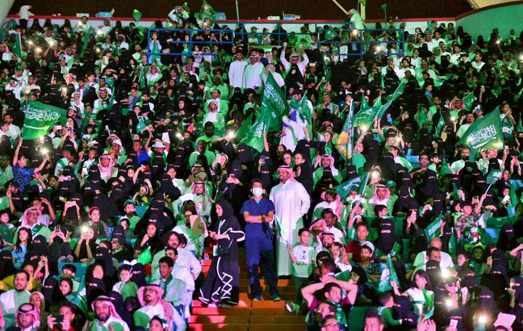 In this Saturday, Sept. 23, 2017 photo released by Saudi Press Agency, SPA, Saudi men and women attend the national day ceremonies at the King Fahd stadium in Riyadh, Saudi Arabia. (Saudi Press Agency via AP)