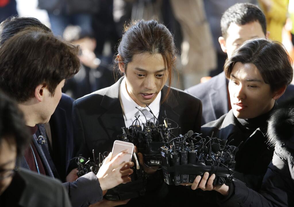 FILE - In this March 14, 2019, file photo, K-pop singer Jung Joon-young, center, speaks upon his arrival at the Seoul Metropolitan Police Agency in Seoul, South Korea. A South Korean court has found two K-pop stars guilty of illicit sexual relations with a woman who was unable to resist and sentenced them to up to six years in prison. The Seoul Central District Court says singer-songwriter Jung received a six-year prison term. (AP Photo/Ahn Young-joon, File)