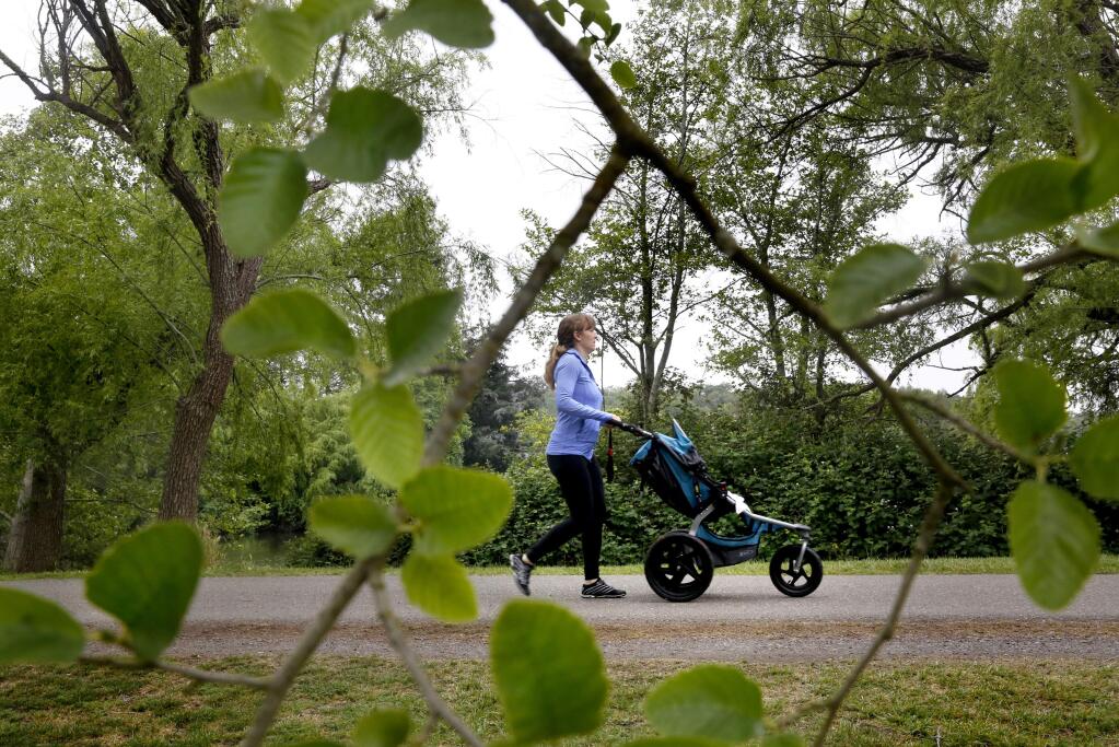 Lily Manspeaker pushes her 8-week-old daughter Harlow in the stroller at Spring Lake Park during in Santa Rosa, on Tuesday, April 21, 2015. (BETH SCHLANKER/ The Press Democrat)