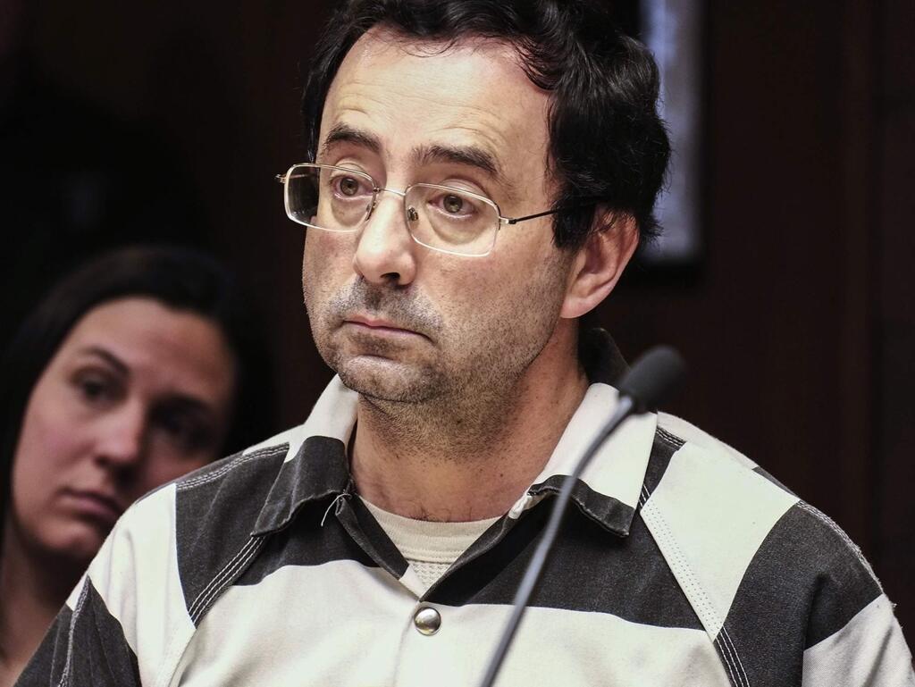 FILE - In this Friday, Feb. 17, 2017, file photo, Dr. Larry Nassar listens to testimony of a witness during a preliminary hearing, in Lansing, Mich. The former sports doctor at Michigan State University who specialized in treating gymnasts has been charged with sexual assault. A person familiar with the situation tells The Associated Press that U.S. Olympic Committee officials will consider recommending the ouster of USA Gymnastics president Steve Penny at their board meeting Thursday, March 9, 2017. (Robert Killips/Lansing State Journal via AP, File)