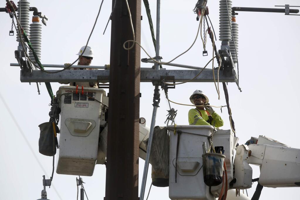 Lineman contracted through PG&E work to dismantle a large utility pole on Trenton Road in Forestville on Monday, October 29, 2018. (BETH SCHLANKER/ The Press Democrat)