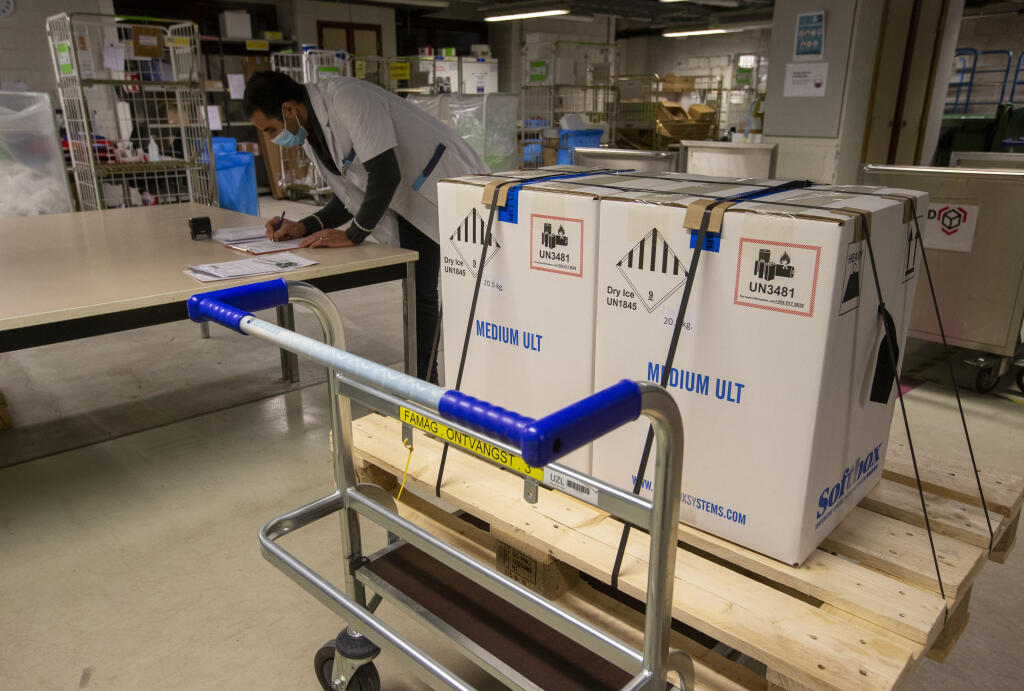 Medical staff receive part of a Pfizer-BioNTech Covid-19 vaccine shipment at the UZ Leuven hospital in Leuven, Belgium, Saturday, Dec. 26, 2020. Belgium is preparing to begin its Covid-19 vaccination program, with first vaccinations beginning on Monday. (Nicolas Maeterlinck, Pool via AP)
