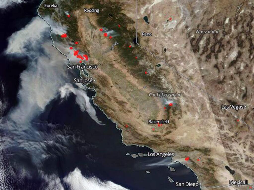 This Oct. 9, 2017 satellite image from the National Oceanic and Atmospheric Administration shows smoke from several fires, noted in red, burning in California, with winds generally blowing from east to west. From the top are the Tubbs and other fires in the Santa Rosa and Napa Valley wine country north of the San Francisco Bay area, top left, several smaller fires in the Sierra Nevada, right center to lower right, and the Canyon 2 fire in Orange County east of Los Angeles, bottom. All graphic material is in the original as released by NOAA. (National Oceanic and Atmospheric Administration/NOAA via AP)