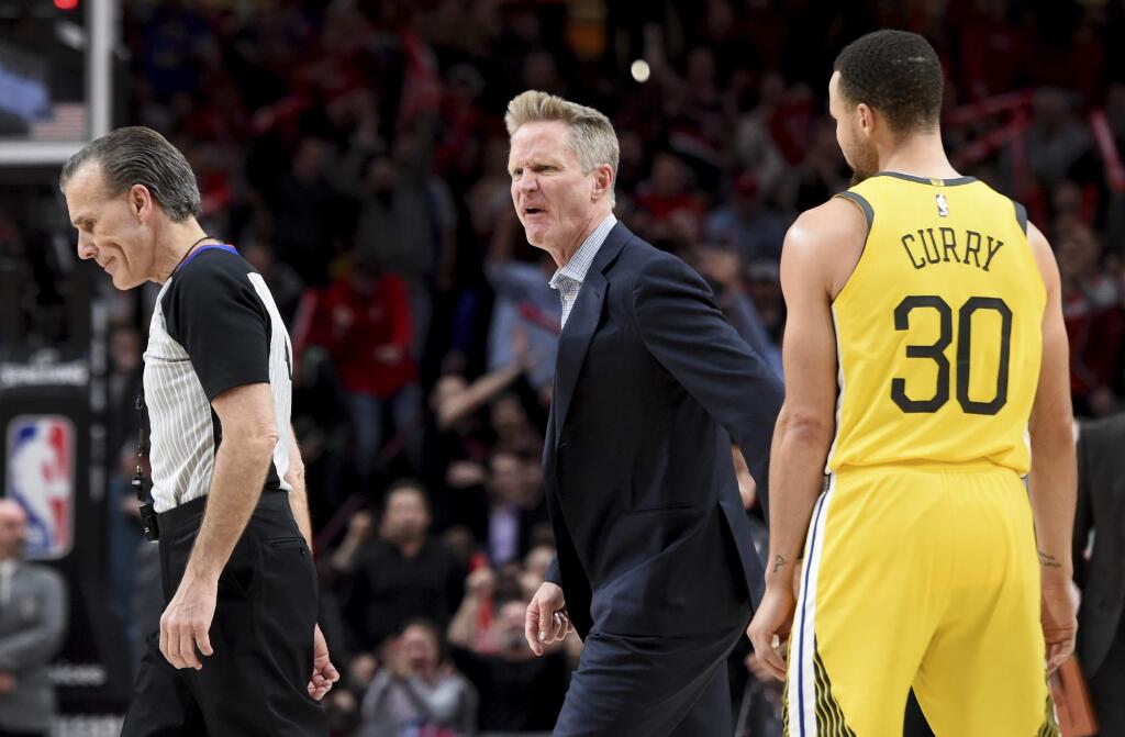Golden State Warriors coach Steve Kerr, center, yells at referee Ken Mauer, left, after being called for a technical foul, while guard Stephen Curry, right, watches during the second half against the Portland Trail Blazers in Portland, Ore., Wednesday, Feb. 13, 2019. The Blazers won 129-107. (AP Photo/Steve Dykes)