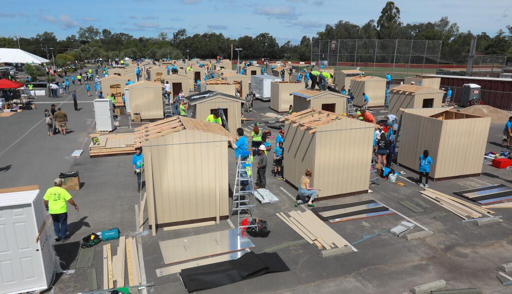 Hundreds of volunteers from across the bay area gathered at Piner High School on Saturday to build and deliver 100 sheds to sites of homes lost in the October wildfires. The sheds will be the first building on many sites and will house tools for the rebuild. (photo by John Burgess/The Press Democrat)