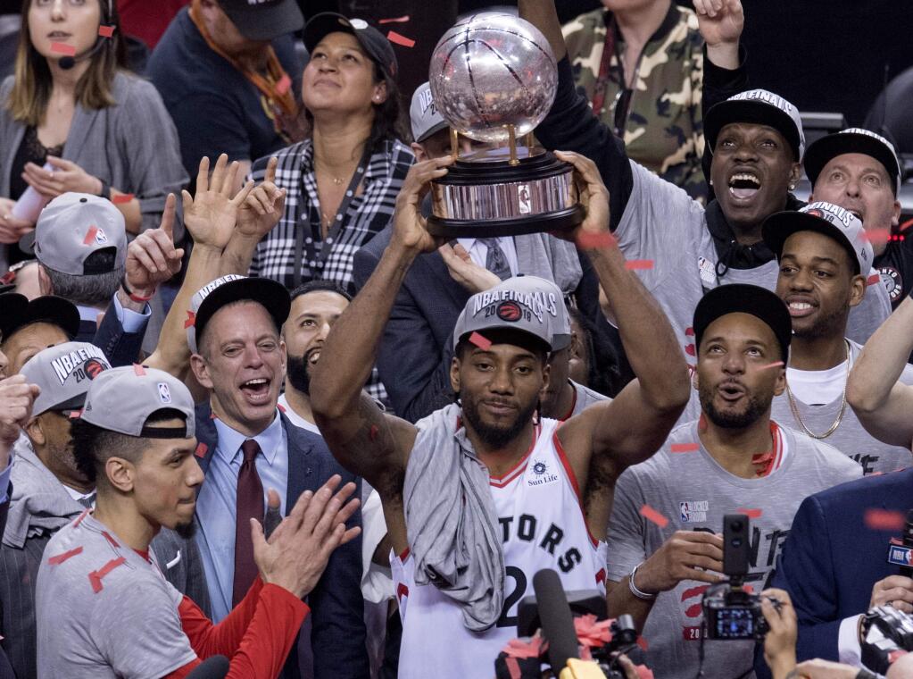 Toronto Raptors' Kawhi Leonard hoists the trophy after the Raptors defeated the Milwaukee Bucks 100-94 in Game 6 of the NBA basketball playoffs Eastern Conference finals Saturday, May 25, 2019, in Toronto. The Raptors advanced to the NBA Finals. (Frank Gunn/The Canadian Press via AP)