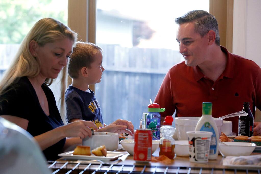 Jeff Okrepkie sits down to dinner with his son Tillman, 2, and wife Stephanie at their home in Santa Rosa, California, on Saturday, September 22, 2018. (Alvin Jornada / The Press Democrat)