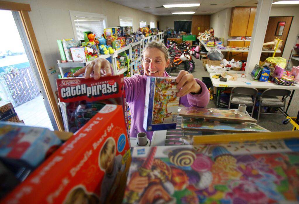 Volunteer Barbara Rossi organizes toys and games donated to the Christmas Cheer toy drive site at First Presbyterian Church of Petaluma on Nov. 24, 2013. (Conner Jay/The Press Democrat)