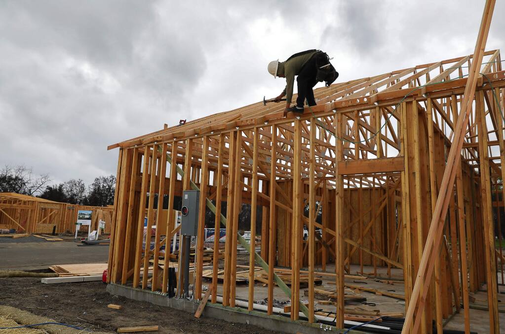 Julio Perez works on the construction of a new home on Willow Green Place, in Larkfield on Wednesday, April 11, 2018. Silvermark Construction is building several new homes on lots that were purchased after the October wildfire. (Christopher Chung/ The Press Democrat)
