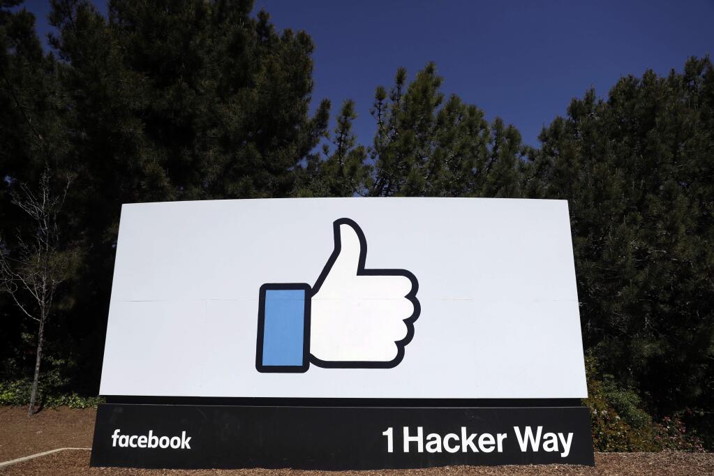 FILE - This March 28, 2018, file photo shows a Facebook logo at the company's headquarters in Menlo Park, Calif. Facebook's ambitious plan to create a new financial system based on a digital currency faces questions from lawmakers, as it's shadowed by negative comments from President Donald Trump, his Treasury secretary and the head of the Federal Reserve. (AP Photo/Marcio Jose Sanchez, File)