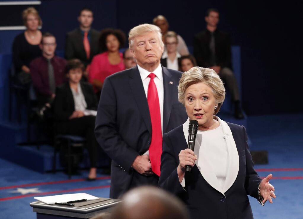 FILE - In this Oct. 9, 2016 file photo, Democratic presidential nominee Hillary Clinton, right, speaks as Republican presidential nominee Donald Trump listens during the second presidential debate at Washington University in St. Louis, Sunday, Oct. 9, 2016. (Rick T. Wilking/Pool via AP)