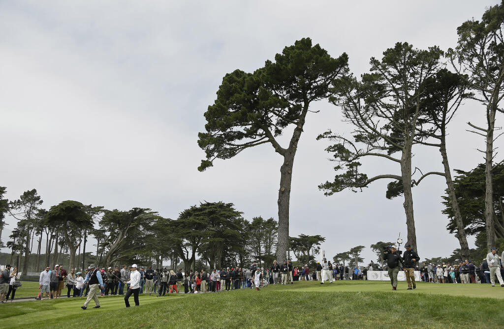 In this  Saturday, May 2, 2015 file photo, Rory McIlroy, left, and Hideki Matsuyama make their way down the fairway after hitting from the eighth tee of TPC Harding Park at the Match Play Championship in San Francisco. Harding Park hosts the PGA Championship on Aug. 6-9, the first major without spectators.  (Eric Risberg / ASSOCIATED PRESS)
