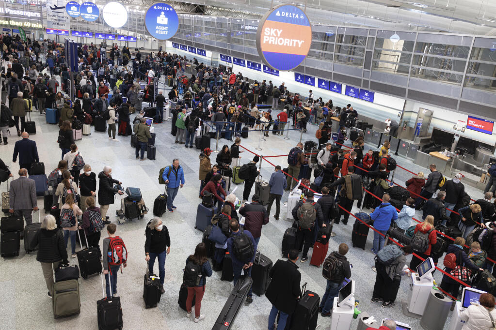 Travelers wait in line to check-in for their flights at Terminal 1 ahead of the Christmas Holiday at MSP Airport in Bloomington, Minn., on Thursday, Dec. 22, 2022. (Kerem Yücel /Minnesota Public Radio via AP)