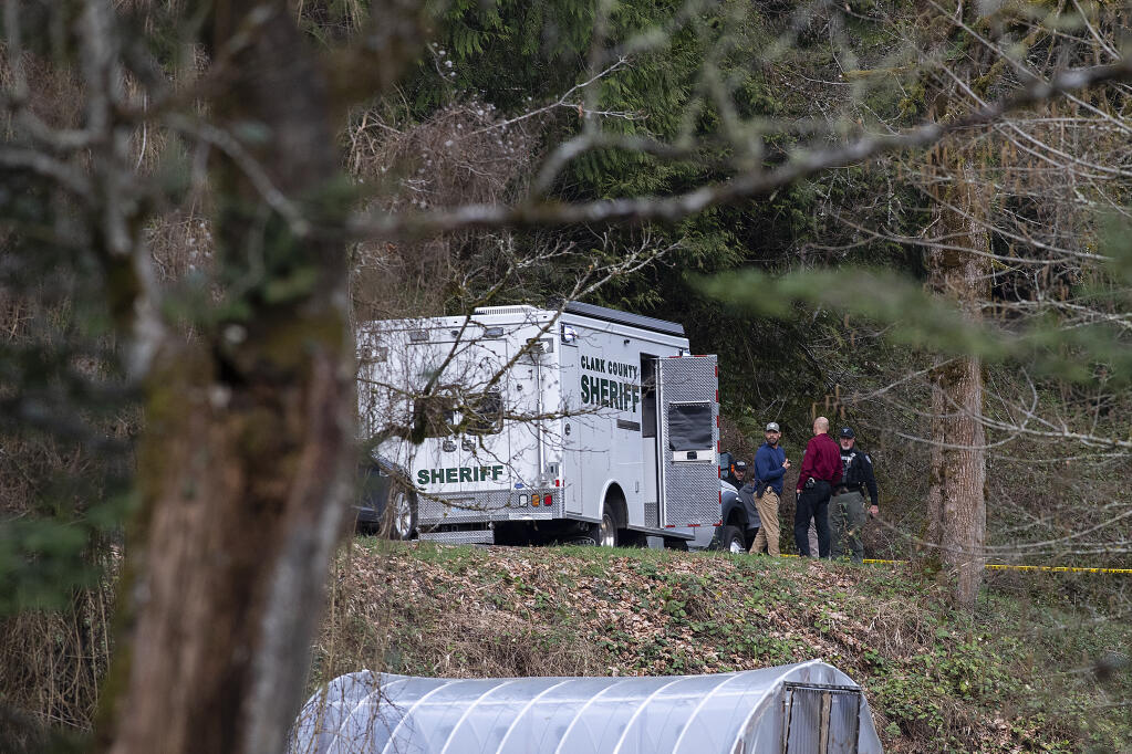 Law enforcement officials work at the scene along Wooding Road on Wednesday, March 22, 2023, east of Washougal, Wash. Authorities found two bodies believed to be those of a missing Vancouver woman and her 7-year-old daughter in a brushy area farther down Wooding Road. (Amanda Cowan/The Columbian via AP)