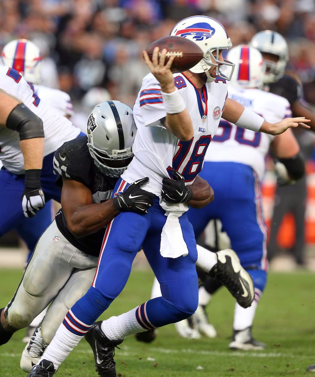 Oakland Raiders defensive end Justin Tuck sacks Buffalo Bills quarterback Kyle Orton in the fourth quarter of their game in Oakland on Sunday, December 21, 2014. The Raiders defeated the Bills 26-24.(Christopher Chung/ The Press Democrat)