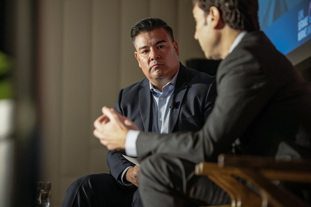 From left, California Insurance Comissioner Ricardo Lara and Raul Vargas, CEO of Farmers Insurance, speak during the Global Sustainable Insurance Summit in downtown Los Angeles on April 4, 2024. Photo by Ted Soqui for CalMatters