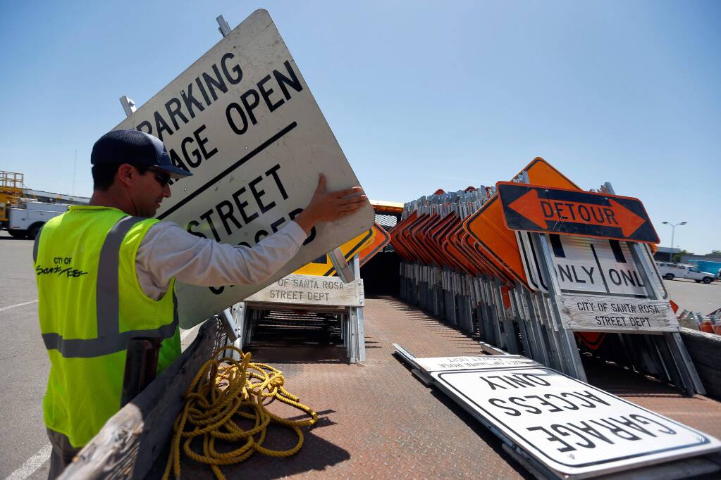 Skilled maintenance worker Alexander Oceguera loads street signs and barricades on the back of a truck at the City of Santa Rosa Municipal Services Center, in preparation for stage 7 of the Amgen Tour of California and Luther Burbank Rose Parade which both occur on Saturday, in Santa Rosa, California on Wednesday, May 18, 2016. (Alvin Jornada / The Press Democrat)