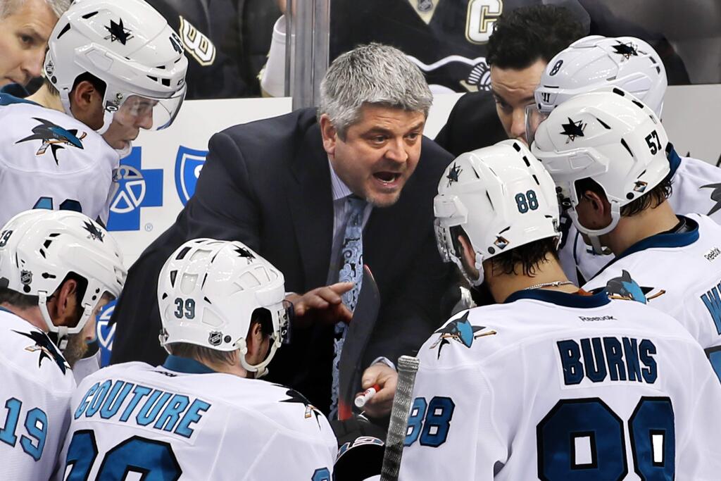 FILE - In this March 29, 2015, file photo, San Jose Sharks head coach Todd McLellan, center, talks to his team during a timeout in the third period of an NHL hockey game against the Pittsburgh Penguins in Pittsburgh. (AP Photo/Gene J. Puskar, File)
