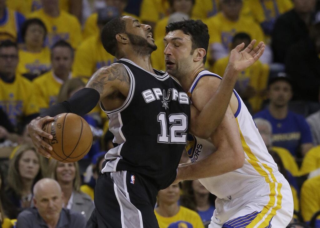 San Antonio Spurs forward LaMarcus Aldridge (12) drives against Golden State Warriors center Zaza Pachulia during the first half of Game 1 of the NBA basketball Western Conference finals in Oakland, Calif., Sunday, May 14, 2017. (AP Photo/Jeff Chiu)