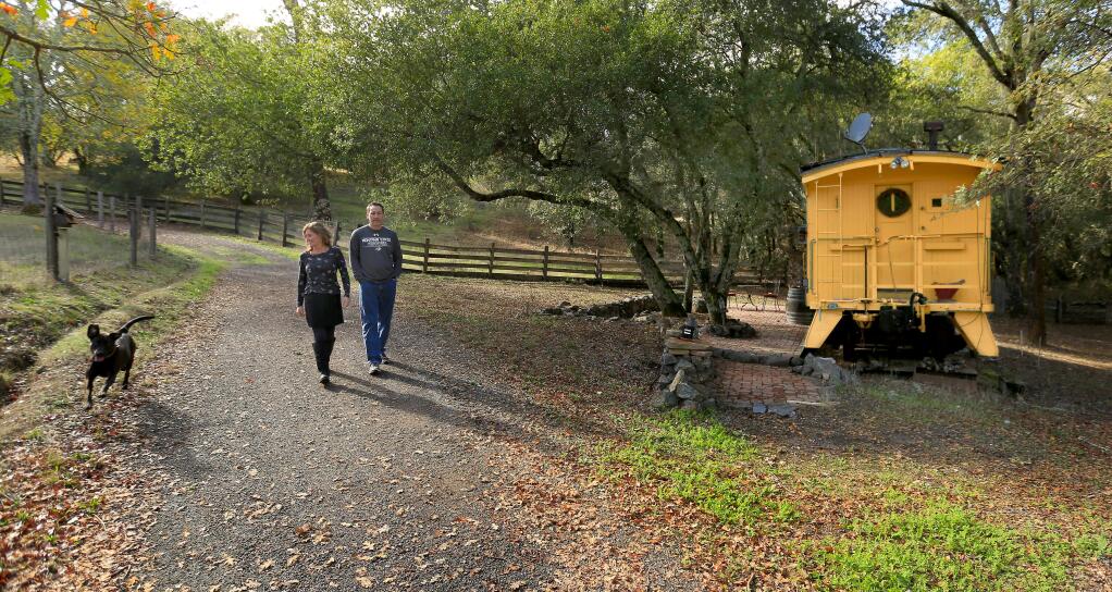 Jennifer and Pat O'Riley of Geyserville take a stroll on their Geyserville property that includes train caboose, left by the previous owners, Friday Nov. 14, 2014. (Kent Porter / Press Democrat) 2014