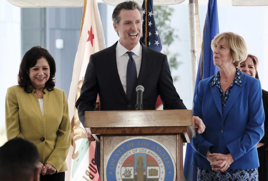 California Gov. Gavin Newsom talks during a news conference while flanked by L.A. County Supervisor Hilda Solis,left and Chair of the Los Angeles County Board of Supervisors Janice Hahn at Rancho Los Amigos National Rehabilitation Center in Downey, Calif. on Wednesday, April 17,2019. (AP Photo/Richard Vogel)