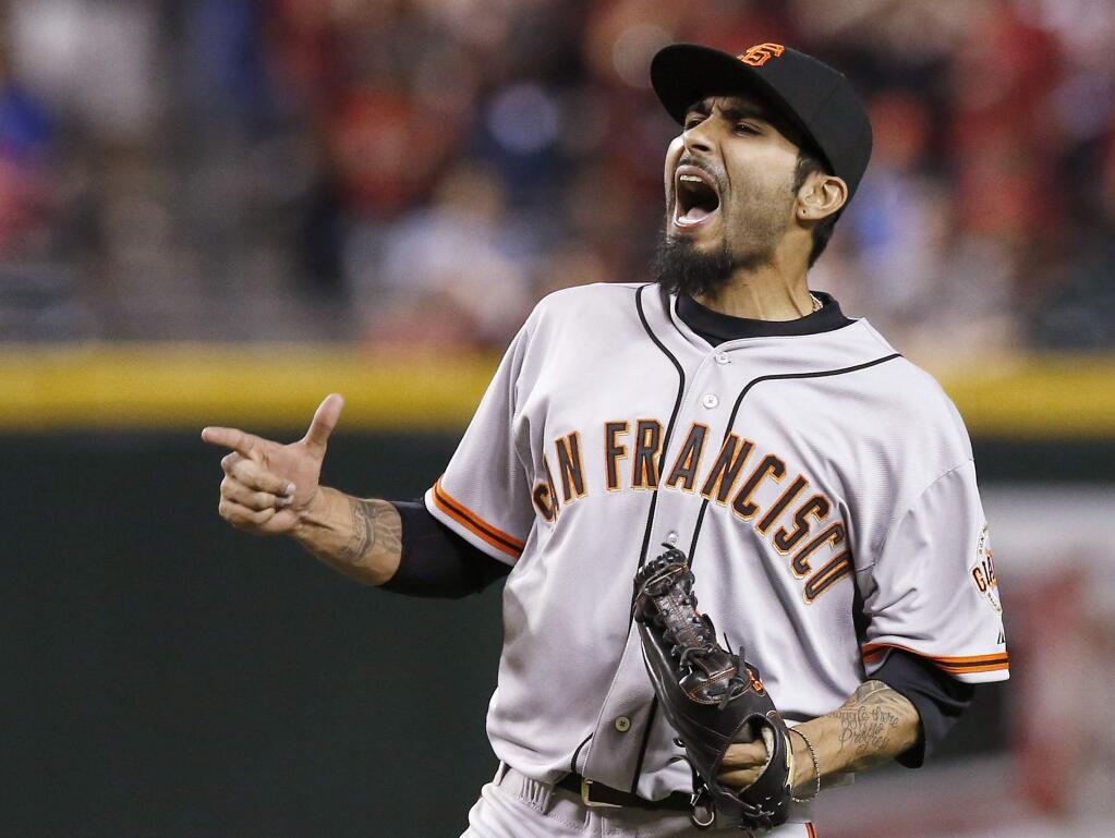 FILE - In a March 31, 2014, file photo San Francisco Giants' Sergio Romo celebrates the final out against the Arizona Diamondbacks during the ninth inning of an opening day baseball game in Phoenix. A person with knowledge of the negotiations says free agent reliever Sergio Romo is closing in on a new contract with the San Francisco Giants. (AP Photo/Ross D. Franklin, file)