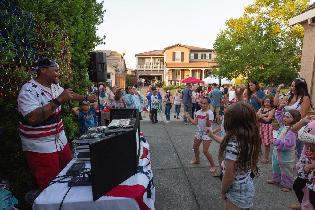 Tai 'DJ Wotai' Gray, left, keeps the party going during Chris and Tiffany Krankemann's annual 4th of July block party before the local fireworks show in Windsor, California, on Wednesday, July 3, 2019. (Alvin Jornada / The Press Democrat)