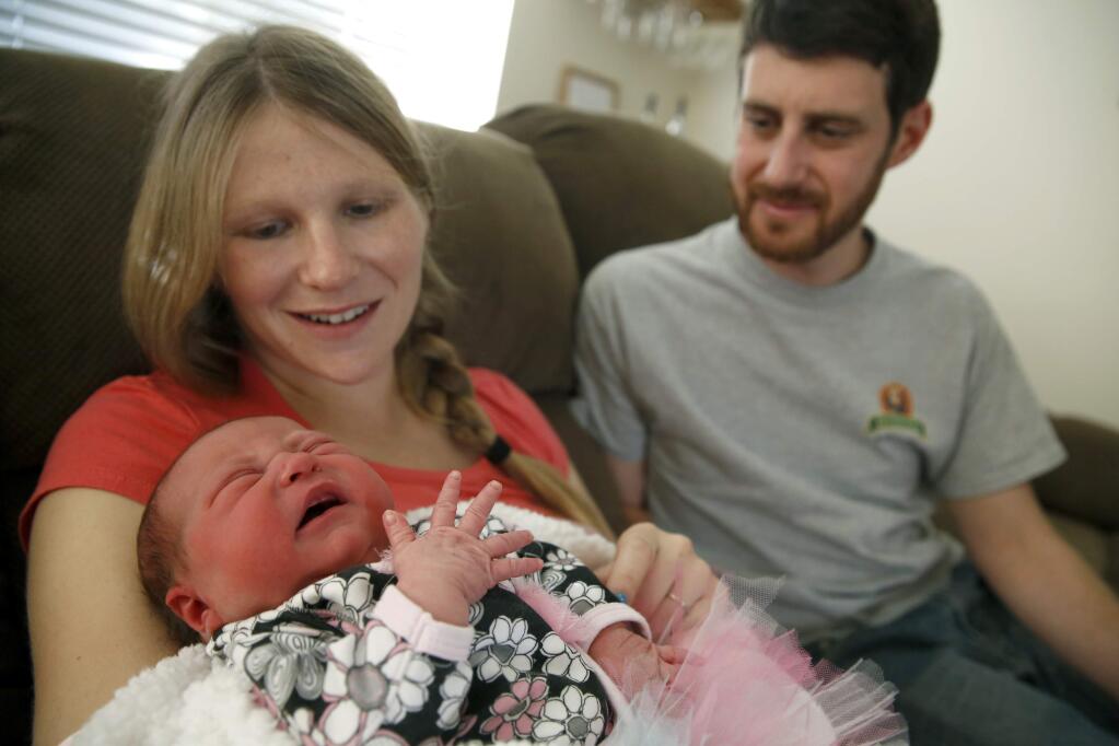 Crystal Reed and her husband, David Chernus, sit with their daughter, Franklynn Robin Chernus, who was born at 1:10 a.m. Thursday, Jan. 1, 2015 at the Santa Rosa Women's Health and Birth Center in Santa Rosa. (BETH SCHLANKER / The Press Democrat)