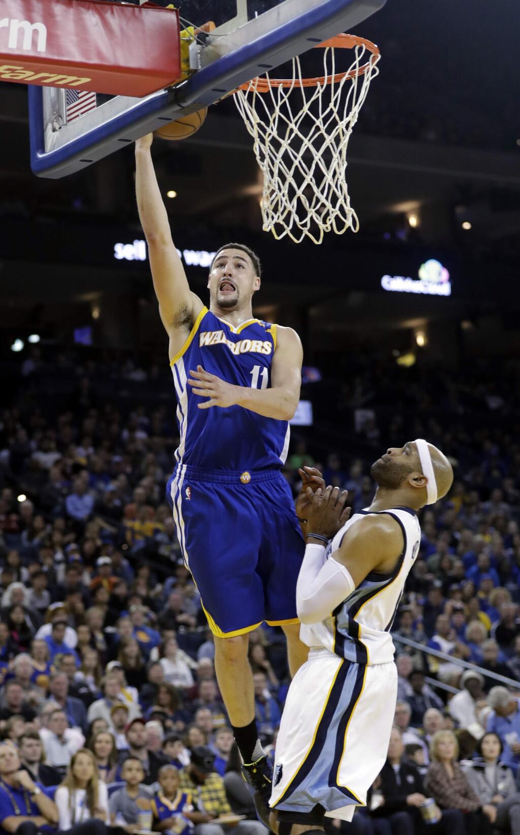 Golden State Warriors' Klay Thompson (11) scores past Memphis Grizzlies' Vince Carter during the second half of an NBA basketball game Sunday, March 26, 2017, in Oakland, Calif. (AP Photo/Marcio Jose Sanchez)