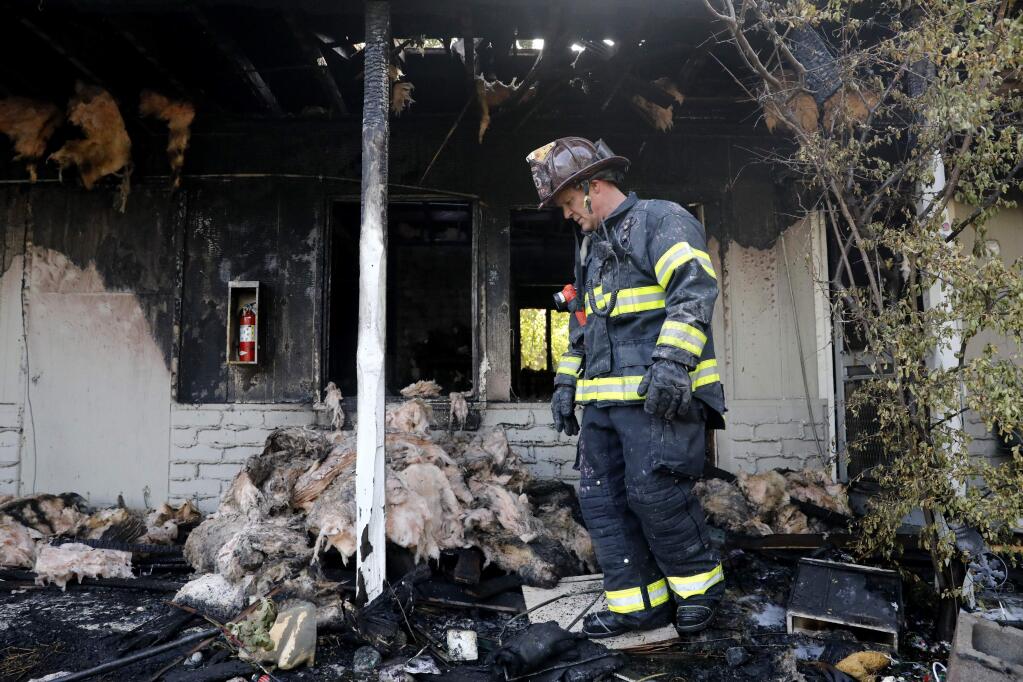 Rincon Valley Fire Capt. Neil Nicholson inspects the damage after a residence burned on the rear of the property at 5519 Old Redwood Hwy on Monday, September 3, 2018 in Santa Rosa, California . (BETH SCHLANKER/The Press Democrat)