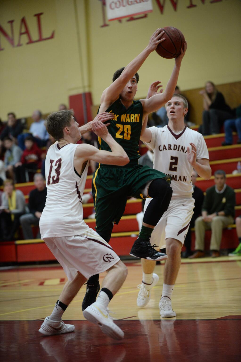San Marin player Tommy Sanz (#20) cutting between Cardinal Newman's Seth Doolittle (#13) and Cody Baker (#2) during the the second half of the Rose City tournament final held at Cardinal Newman in Santa Rosa Saturday evening. San Marin won 51 to 32. December 12, 2015. (Photo: Erik Castro/for The Press Democrat)