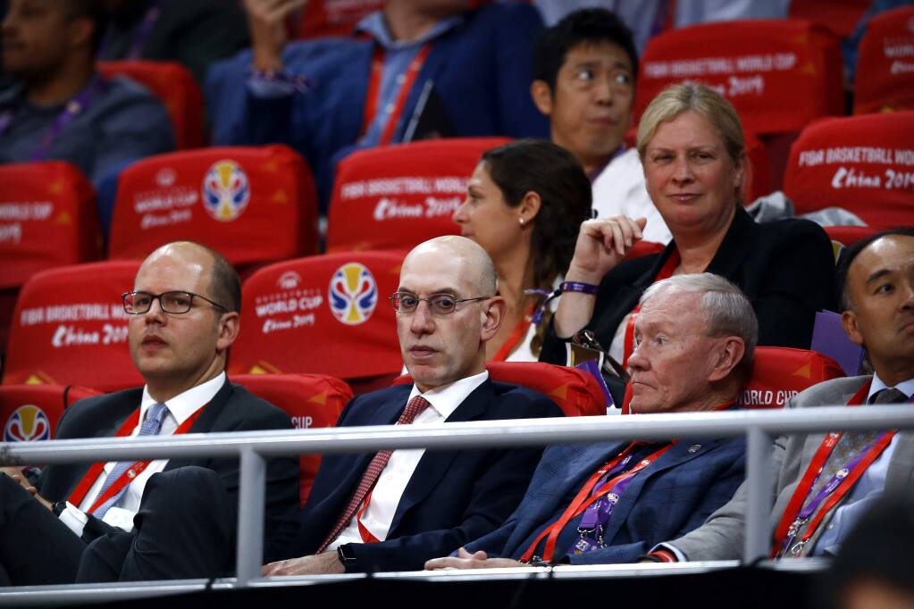 FILE - In this Sept. 13, 2019, file photo, NBA Commissioner Adam Silver, second from left, attends the semifinal match between Argentina and France in the FIBA Basketball World Cup at the Cadillac Arena in Beijing. The multibillion-dollar relationship between China and the NBA is strained right now in ways unlike any other since the league first began planting roots there three decades ago. (AP Photo/Mark Schiefelbein, File)
