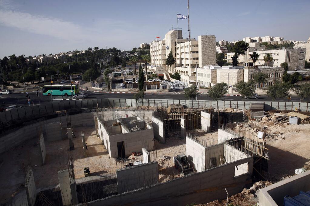 FILE - This May 17, 2016 file photo shows construction on land owned by Palestinian Mohammad Abu Ta'a, in east Jerusalem. Abu Ta'a discovered some years ago that the Israeli government had expropriated the piece of land in Jerusalem belonging to his family and handed it over to a leading organization that oversees Jewish settlement building in the West Bank. The U.N. Security Council prepared Friday for perhaps its biggest vote in recent history as the United States weighed abstaining from a resolution that would condemn Israeli settlement construction in the West Bank and east Jerusalem. Behind the scenes, U.S. and Israeli officials exchanged surprisingly sharp words for allies. (AP Photo/Mahmoud Illean)