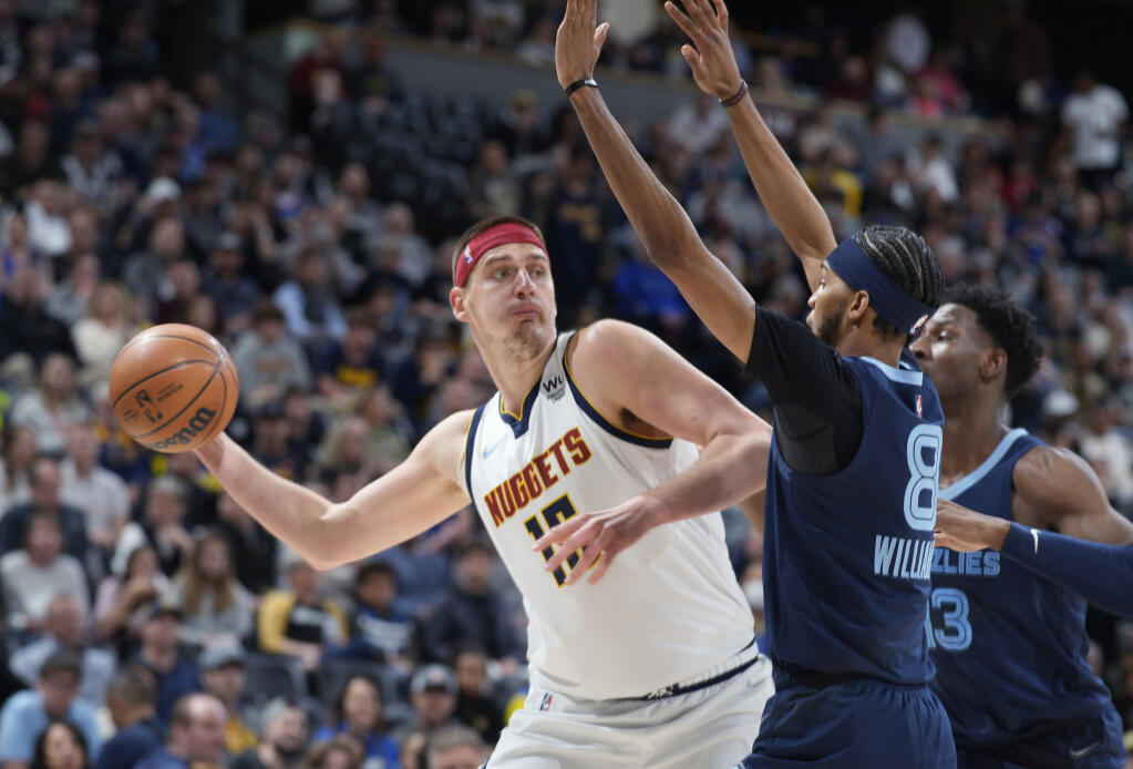 Nuggets center Nikola Jokic looks to pass the ball as Memphis Grizzlies guard Ziaire Williams, front, and forward Jaren Jackson Jr. defend during the first half on April 7, 2022, in Denver. (David Zalubowski / ASSOCIATED PRESS)