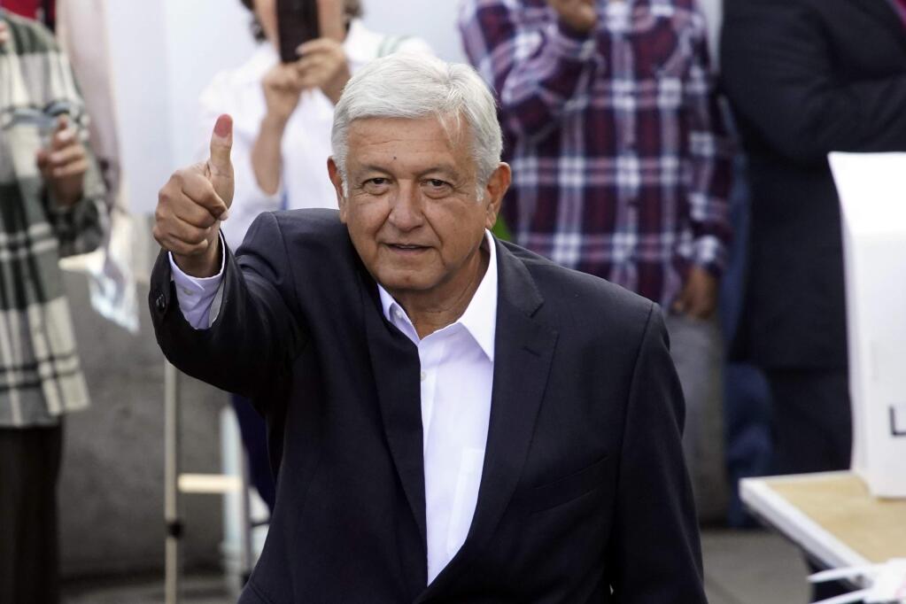 Presidential candidate Andres Manuel Lopez Obrador, of the MORENA party, shows hs ink-stained thumb after casting his vote at a polling station during general elections in Mexico City, Mexico, Sunday, July 1, 2018. (AP Photo/Ramon Espinosa)