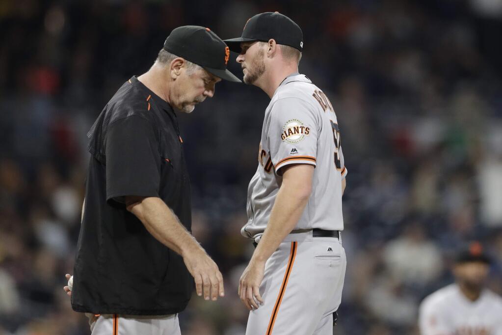 San Francisco Giants relief pitcher Matt Reynolds, right, passes manager Bruce Bochy, left, as he leaves the game after giving up three runs during the fifth inning against the San Diego Padres Friday, Sept. 23, 2016, in San Diego. (AP Photo/Gregory Bull)