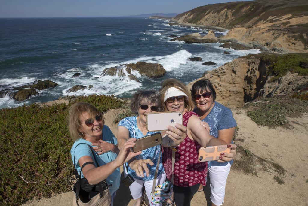 From left, Maria Hamm, Nancy Beardsley, Jeannie Driekosen and CeCe Bonardi take multiple selfies while visiting Bodega Head. The friends from Petaluma headed to the coast for a girls weekend to beat the 100 degree temperatures on Friday. (photo by John Burgess/The Press Democrat)