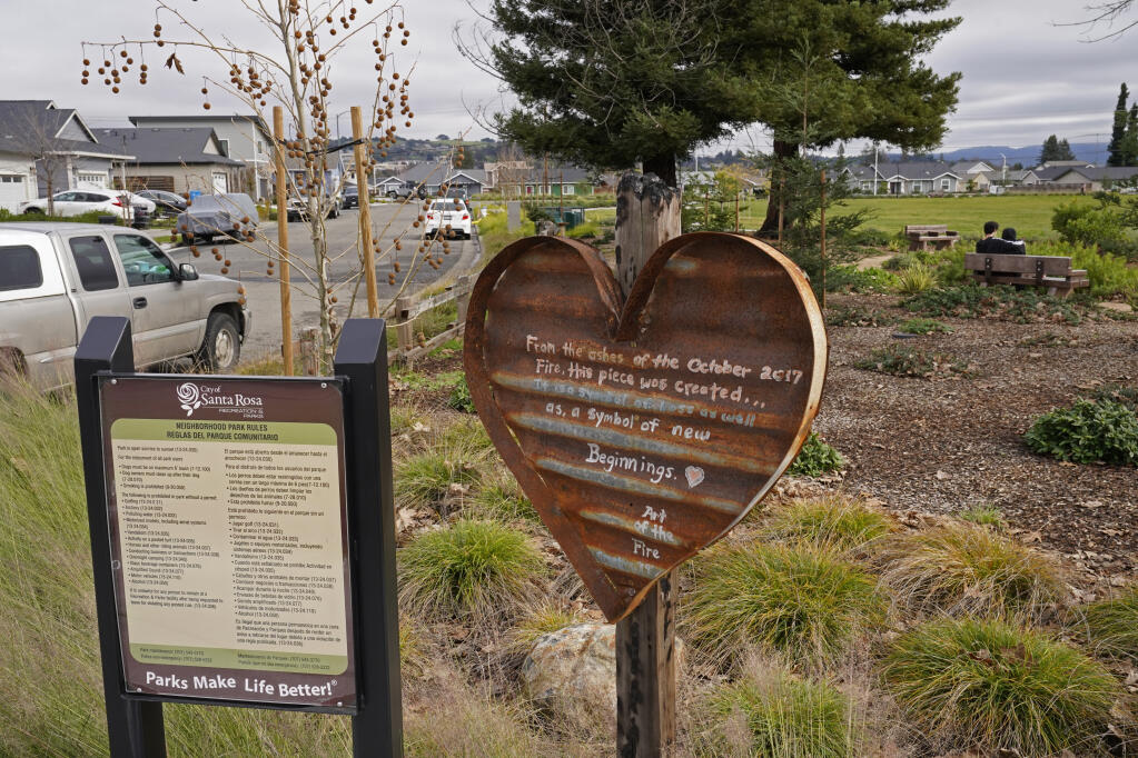 A sign remembering the fire of October 2017 is displayed in the rebuilt Coffey Park area of Santa Rosa, Calif., Wednesday, Jan. 5, 2022. The 2017 Tubbs fire destroyed over 3,000 residential units in the Northern California city of Santa Rosa, including more than 1,400 homes in the Coffey Park neighborhood. Four years later, about 90% of the units have been rebuilt or are in the process of being constructed, city officials said. (AP Photo/Eric Risberg)
