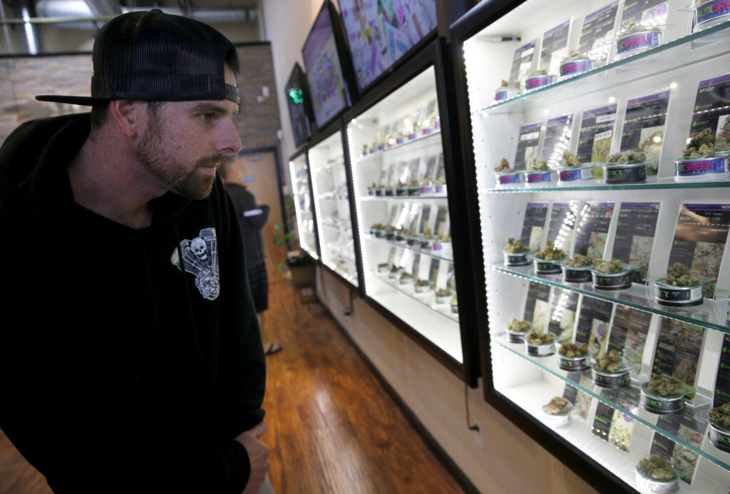 Chris Hillenbrand browses the variety of marijuana for sale at Mercy Wellness cannabis dispensary in Cotati, Thursday, Dec. 28, 2017. (Beth Schlanker / The Press Democrat file)