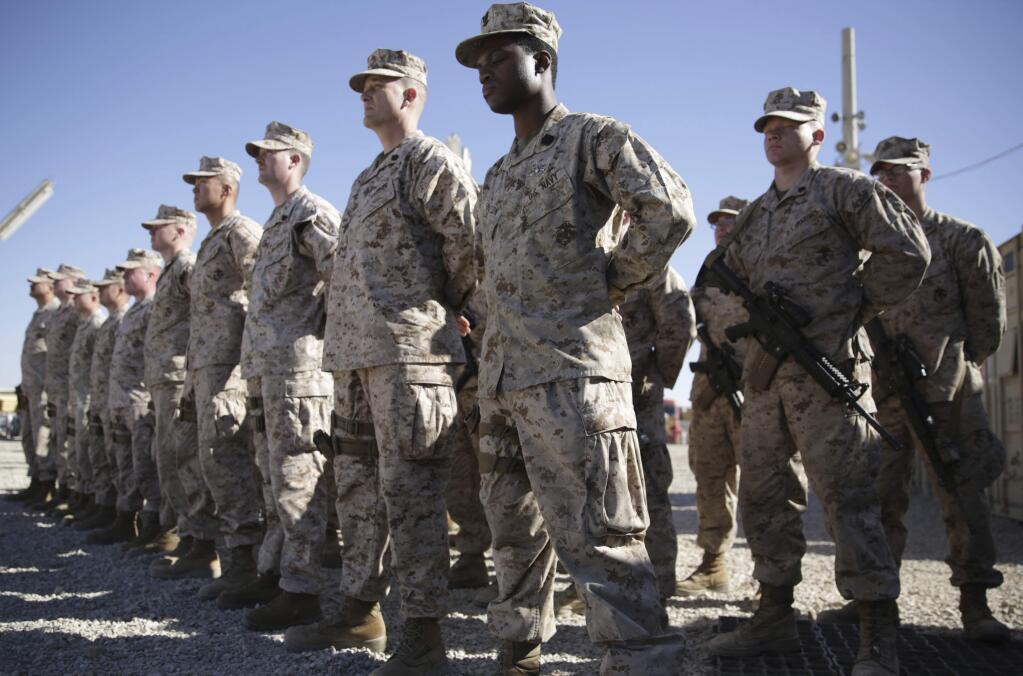 FILE - In this Jan. 15, 2018 file photo, U.S. Marines stand guard during the change of command ceremony at Task Force Southwest military field in Shorab military camp of Helmand province, Afghanistan. The Pentagon is developing plans to withdraw up to half of the 14,000 American troops serving in Afghanistan, U.S. officials said Thursday, Dec. 20, 2018, marking a sharp change in the Trump administration's policy aimed at forcing the Taliban to the peace table after more than 17 years of war. (AP Photo/Massoud Hossaini, File)