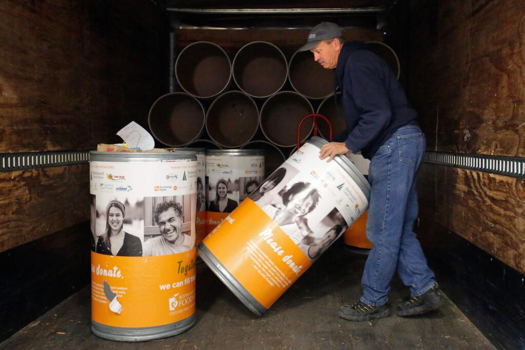 Driver Duane Anderson unloads full donation barrels from a truck at the Redwood Empire Food Bank in Santa Rosa, California on Thursday, December 21, 2017. (Alvin Jornada / The Press Democrat)