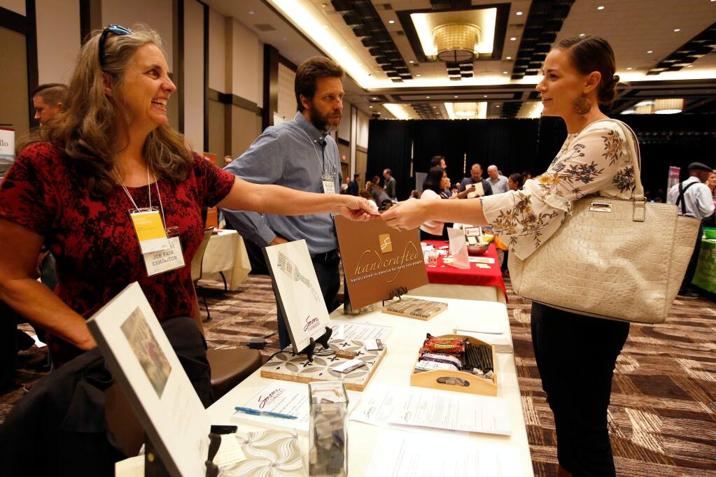 Kayanna Walstrand, right, of Windsor talks with Dana Higgins, left, and Sergio Garcia of Sonoma Tilemakers during the Rebuilding Sonoma County Job Fair at Graton Resort and Casino in Rohnert Park, California on Tuesday, November 7, 2017. (Alvin Jornada / The Press Democrat)