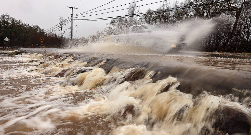 Green Valley Rd. at Green Valley Creek remained open and passable as flood water falls over the lip of the creek, Saturday, Dec. 31, 2022, near Graton. (Kent Porter / The Press Democrat) 2022