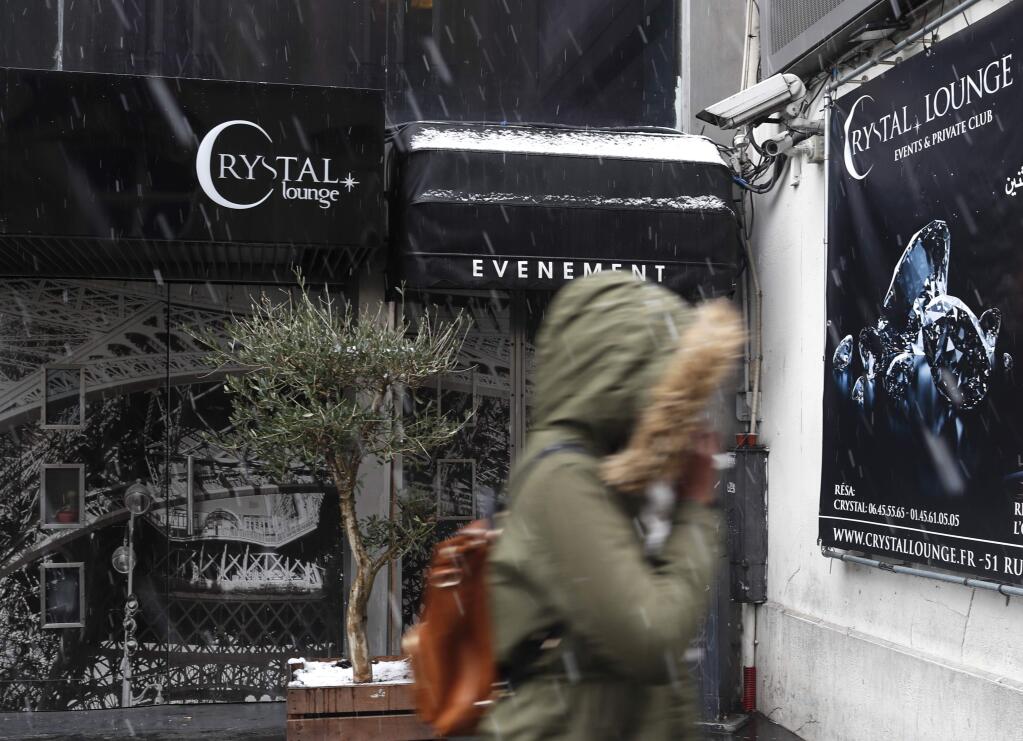 A woman walks past the Crystal Club in Paris, Tuesday Jan.22, 2019. (AP Photo/Thibault Camus)