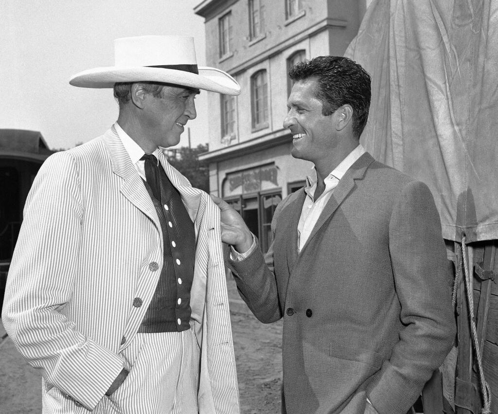 FILE - In this Oct. 24, 1963 file photo, actors James Stewart, left, and Hugh O'Brian confer on the set of 'Cheyenne Autumn' in Los Angeles. In the movie, Stewart plays the role of Wyatt Earp, whom O'Brian portrayed on the 1950s television series 'The Life and Legend of Wyatt Earp.' O'Brian has died at the age of 91. He passed away at this home in Beverly Hills Monday morning, Sept. 5, 2016, according to a statement from HOBY, a youth leadership philanthropic organization that O'Brian founded over 50 years ago. (AP Photo/DAB)
