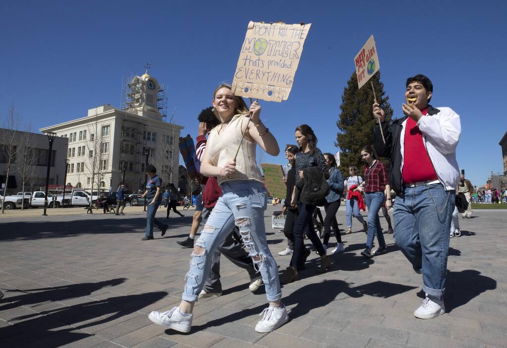Rancho Cotate sophomores Amanda Knox and Edgar Enriquez, both 16, march down Santa Rosa Avenue to City Hall to demand action against climate change. The rally was a coordinated event with students around the United States and the world. (photo by John Burgess/The Press Democrat)